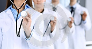 Group of doctors holding stethoscope head close-up. Physicians ready to examine and help patient. Medical help