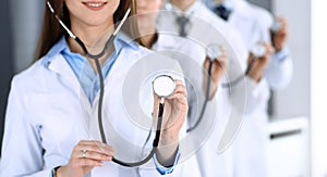 Group of doctors holding stethoscope head close-up. Physicians ready to examine and help patient. Medical help