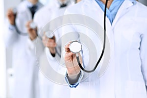 Group of doctors holding stethoscope head close-up. Physicians ready to examine and help patient. Medical help