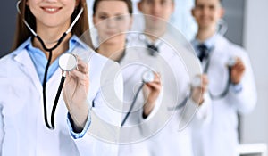 Group of doctors holding stethoscope head close-up. Physicians ready to examine and help patient. Medical help