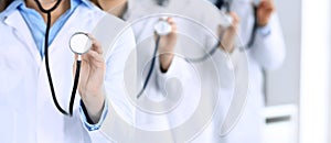 Group of doctors holding stethoscope head close-up. Physicians ready to examine and help patient. Medical help