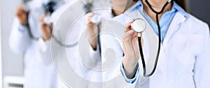 Group of doctors holding stethoscope head close-up. Physicians ready to examine and help patient. Medical help