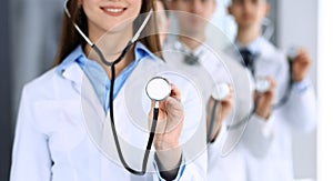 Group of doctors holding stethoscope head close-up. Physicians ready to examine and help patient. Medical help