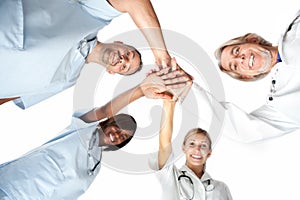 Group of doctors joining hands with low angle view