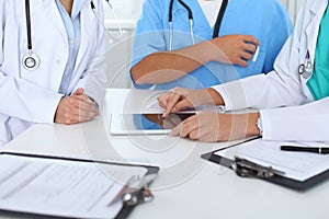 Group of doctors at medical meeting. Close up of physician using touch pad or tablet computer
