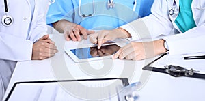 Group of doctors at medical meeting. Close up of physician using touch pad or tablet computer