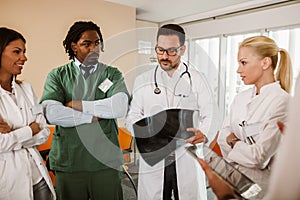 Group of doctors and nurses in meeting cooperating to make diagnose