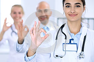 Group of doctors showing OK or approval sign with thumb up. High level and quality medical service, best treatment and