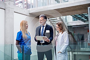 Group of doctors talking to pharmaceutical sales representative.