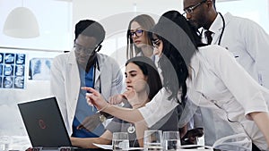 Group of doctors using laptop together in the conference room.