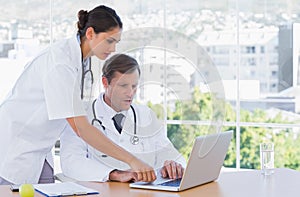 Group of doctors working together on a laptop