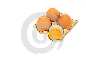 A group of eggs and fresh half-cracked egg in brow paper tray isolated.