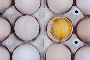 Group of eggs - one broken with yolk on the top.