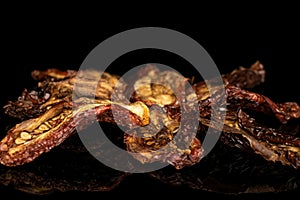 Sun dried tomato isolated on black glass