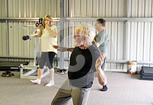 Group of elderly senior people practicing Tai chi class in age care gym facilities