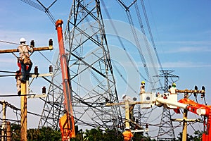 group of electric worker working on pole connected high voltage wires under high voltage pole