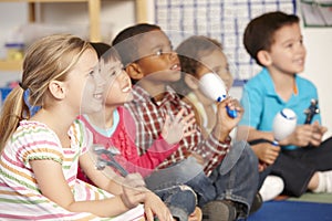 Group Of Elementary Age Schoolchildren In Music Class With Instruments