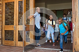 Group of elementary children running outside school