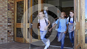 Group of elementary children running outside school