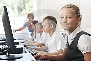 Group Of Elementary Pupils In Computer Class With Teacher