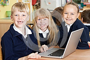Group Of Elementary School Children Working Together In Computer