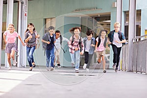 Group of elementary school kids running in a school corridor