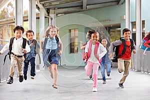 Group of elementary school kids running in a school corridor