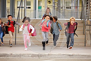 A group of elementary school kids rushing out of school photo