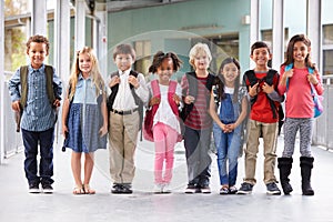 Group of elementary school kids standing in school corridor