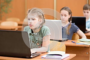 Group of elementary school kids working together in computer class