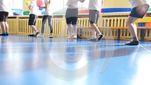 Group of elementary students exercising during class at school gym. Kids running in kindergarten gym. Children training