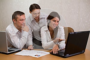 Group of employees in the office with laptops