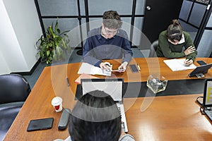 Group of employees sitting around the office meeting table