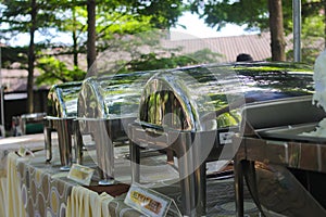 a group of Empty buffets with blurred background is being set up for an outdoor wedding concept