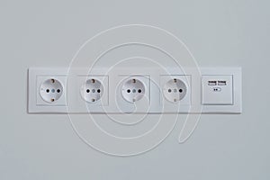 Group of empty white electrical european outlet located on gray wall - close up