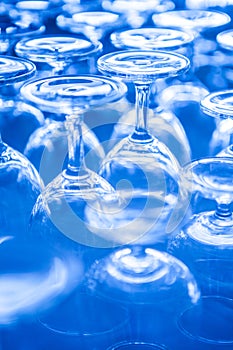 Group of empty wine glass upside down in row blue tone