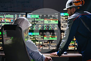 Group of engenners following production line using computer screens with Industry 4.0. Couple of factory operators controll