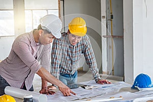 Group of engineer checking the blueprint on the table and talking about construction project with commitment to success at