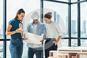 Group of engineer looking at project plan while brainstorming idea. Tracery.