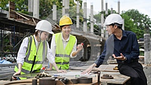 Group of engineer supervisor wearing safety helmet working, checking plan together at construction site