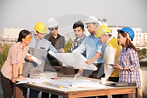 Group of engineers and architects discuss at a construction site