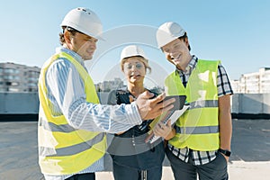 Group of engineers, builders, architects on the building site. Construction, development, teamwork and people concept