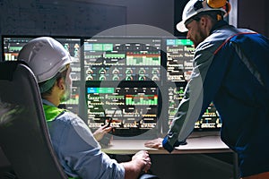 Group of engineers following production line using computer screens with Industry 4.0. Couple of factory operators controll assemb