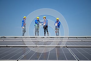 Group of engineers standing on solar panels with blue sky