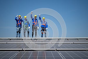 Group of engineers standing on solar panels with blue sky