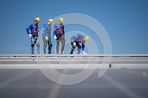 Group of engineers standing on solar panels with blue sky