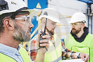 Group of engineers using walkie-talkie talking on produce site