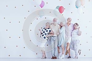 Group of enthusiastic elderly people with colorful balloons