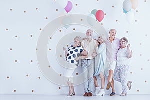 Group of enthusiastic elderly people with colorful balloons photo