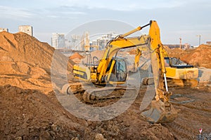 Group of the excavators for dig ground trenching at a construction site for foundation and installing storm pipes.